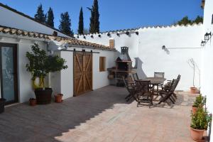 eine Terrasse mit einem Tisch, Stühlen und einem Herd in der Unterkunft Casa Cal Tòfol in Font-Rubí