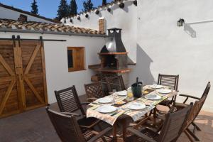 una mesa y sillas en un patio con chimenea en Casa Cal Tòfol, en Font-Rubí