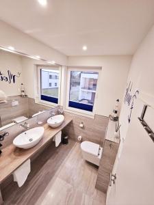 ein Badezimmer mit zwei Waschbecken und einem großen Spiegel in der Unterkunft Sonnendeck Schwerin in Schwerin