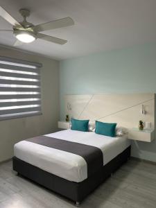 um quarto com uma cama grande e almofadas azuis em Constanza Lofts Executives en Zapopan Jalisco em Guadalajara