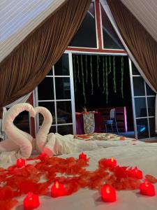 uma cama com dois cisnes feitos de pétalas de rosa em ADIL WATERHOUSE RESORT em Semporna