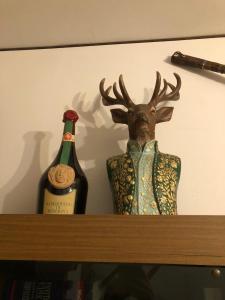 una bottiglia di vino e una testa di cervo su uno scaffale di I Due Cervi a Portico di Romagna
