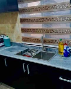 - un comptoir de cuisine avec un évier et un comptoir dans l'établissement Enugu Airbnb / shortlet Serviced Apartment, à Enugu