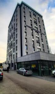 a large building with cars parked in front of it at Apartamenty Centrum Wigury Parking Dostęp Na Kod in Łódź