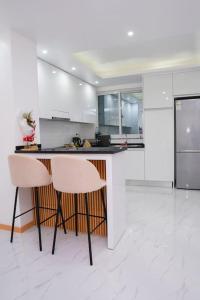 a white kitchen with two chairs and a counter at Saw Paradise in Praia T2 in Praia