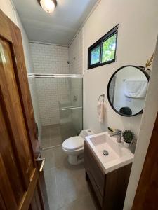 ein Badezimmer mit einem WC, einem Waschbecken und einem Spiegel in der Unterkunft Nativo in Santa Catalina