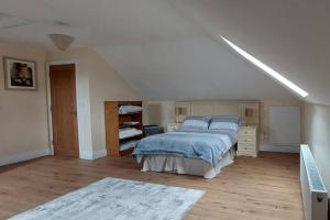 Modern Countryside apartment Killmallock Lodge في إينيسكورثي: غرفة نوم بسرير كبير في غرفة بيضاء