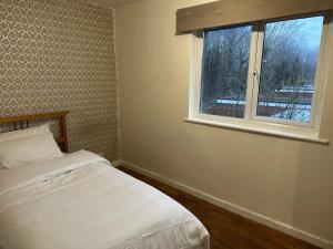 a bedroom with a bed and a window at Patchway Homestay in Bristol