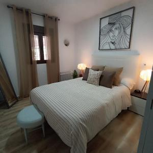a bedroom with a large bed and a blue stool at Alojamiento Rural Mariola in La Iruela
