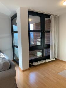 un soggiorno con una grande finestra e un divano di Comfort Apartment Düsseldorf Messe 2 rooms with kitchen, balcony, parking and elevator a Dusseldorf