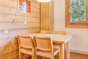 a dining room with a wooden table and chairs at Résidence Plagne Lauze - maeva Home - Studio 4 Personnes - Sélection MAE-4354 in Mâcot La Plagne