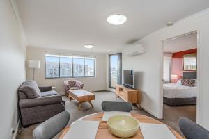 sala de estar con sofá y cama en CityStyle Apartments, en Canberra