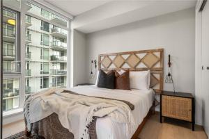 sypialnia z dużym łóżkiem i dużym oknem w obiekcie Manhattan w mieście Calgary