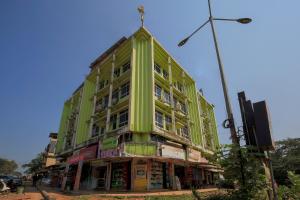 un edificio verde con una cruz encima en Collection O Hotel Sincro en Madgaon