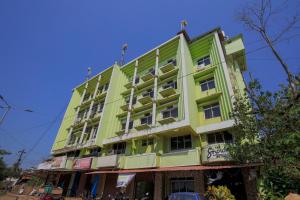 un edificio amarillo y verde en una calle en Collection O Hotel Sincro en Madgaon