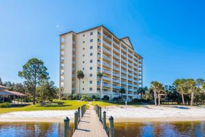 a building on the beach next to a body of water at Sailmakers Place 703 in Perdido Key