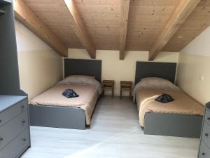 2 Betten in einem Zimmer mit Holzdecken in der Unterkunft Welcome Milano Guest House in Mailand