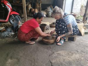 Dos mujeres están jugando con una olla en el suelo en Bale Tetebatu, en Tetebatu