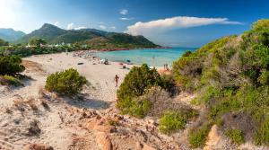 a beach with a group of people in the water at Bellevue Bari Sardo in Bari Sardo
