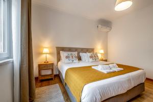 a bedroom with a large bed with two towels on it at Villa Laranja-Limao - NEW in Azeitao