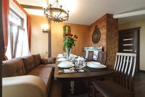 a dining room with a table and a couch at StoneBridgeLuxApart Free Parking in Rīga