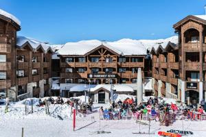 a group of people in the snow in front of a ski lodge at Résidence Les Cimes Blanches - 4 Pièces pour 6 Personnes 414 in Courchevel