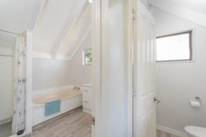 une salle de bain blanche avec une baignoire et un lavabo dans l'établissement Perfect Picture on Haddon, à Whitianga 51 autres photos