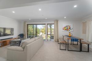 un salon avec un canapé blanc et une table dans l'établissement Perfect Picture on Haddon, à Whitianga