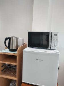 a microwave oven sitting on top of a refrigerator at House of Peace in Oxford