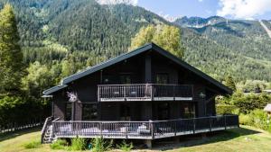 Blockhaus mit Balkon und Bergen im Hintergrund in der Unterkunft Résidence Le Sorbier - 5 Pièces pour 6 Personnes 784 in Chamonix-Mont-Blanc