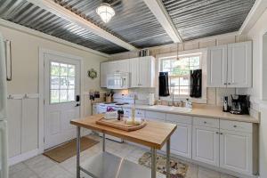 cocina con armarios blancos y mesa de madera en Dwtn Franklin - Walkable with Huge Yard Sleeps 6, en Franklin