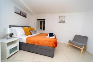 1 dormitorio con 1 cama y 1 silla en Spacious Flat with Patio & Parking in city centre en Reading
