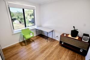 an empty room with a desk and a green chair at Beach House with Sea Views and a Large Backyard in Devonport