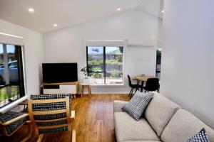 ein Wohnzimmer mit einem Sofa und einem Tisch in der Unterkunft Beach House with Sea Views and a Large Backyard in Devonport
