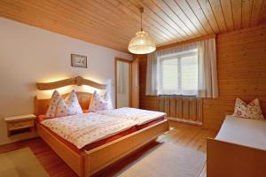 a bedroom with a bed in a wooden room at Gugghof in Hopfgarten im Brixental