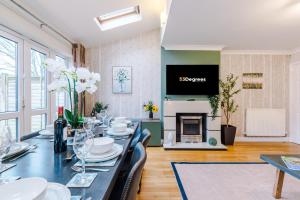 a dining room with a long table and a fireplace at NEW! Incredible Home In Northwich By 53 Degrees Property, Perfect For Groups, FREE Parking! in Northwich