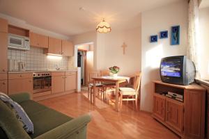 a kitchen and living room with a tv and a table at Gugghof in Hopfgarten im Brixental