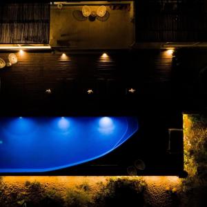 uma piscina azul com luzes no escuro em The Blue House Valley em Grândola