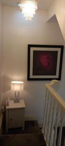 a staircase with a lamp and a picture on the wall at Serene Homes Sheffield, Private Ensuite Velux Room in Hillsborough