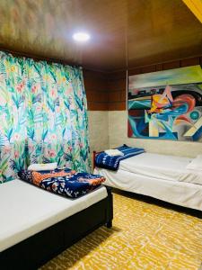 two beds in a room with a painting on the wall at Finca turística VILLA OFELIA in Quimbaya
