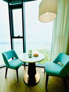 a table and two chairs in a room with a window at Panoramic sea homestay in Ha Long