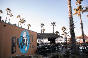 un restaurante con mesas, sillas y palmeras en Paradise Point Resort & Spa, en San Diego