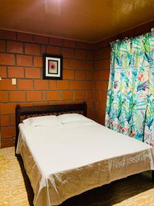 a bed in a room with a brick wall at Finca turística VILLA OFELIA in Quimbaya