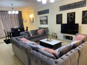 een woonkamer met banken en een flatscreen-tv bij Appartement K.N.Y in Yaoundé