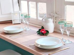 a table with plates and wine glasses on it at Appartement Bulle d'antan en cœur de ville - Monument classé historique - Grand Jaccuzi in Castres