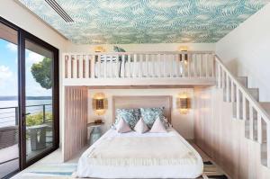 1 dormitorio con cama blanca y altillo en Villa Cinco Monos, en Liberia