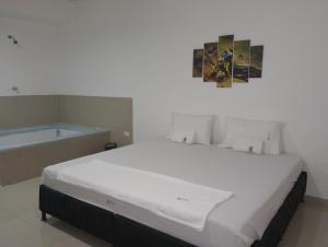 een slaapkamer met een groot bed en een bad bij Hotel El refugio Doradal in Puerto Triunfo