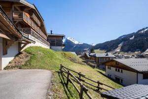 Ein Hügel mit einem Zaun neben einem Gebäude in der Unterkunft Résidence Les Balcons Des Bois Venants Bat A - Pièces 444 in Morzine