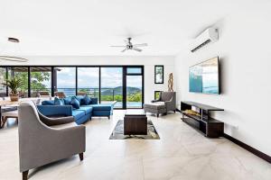 a large living room with a blue couch and chairs at Casa del Buho in Playa Hermosa