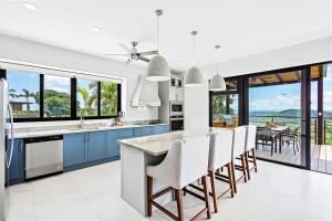 una cocina con armarios azules y una mesa con sillas en Casa del Buho en Playa Hermosa